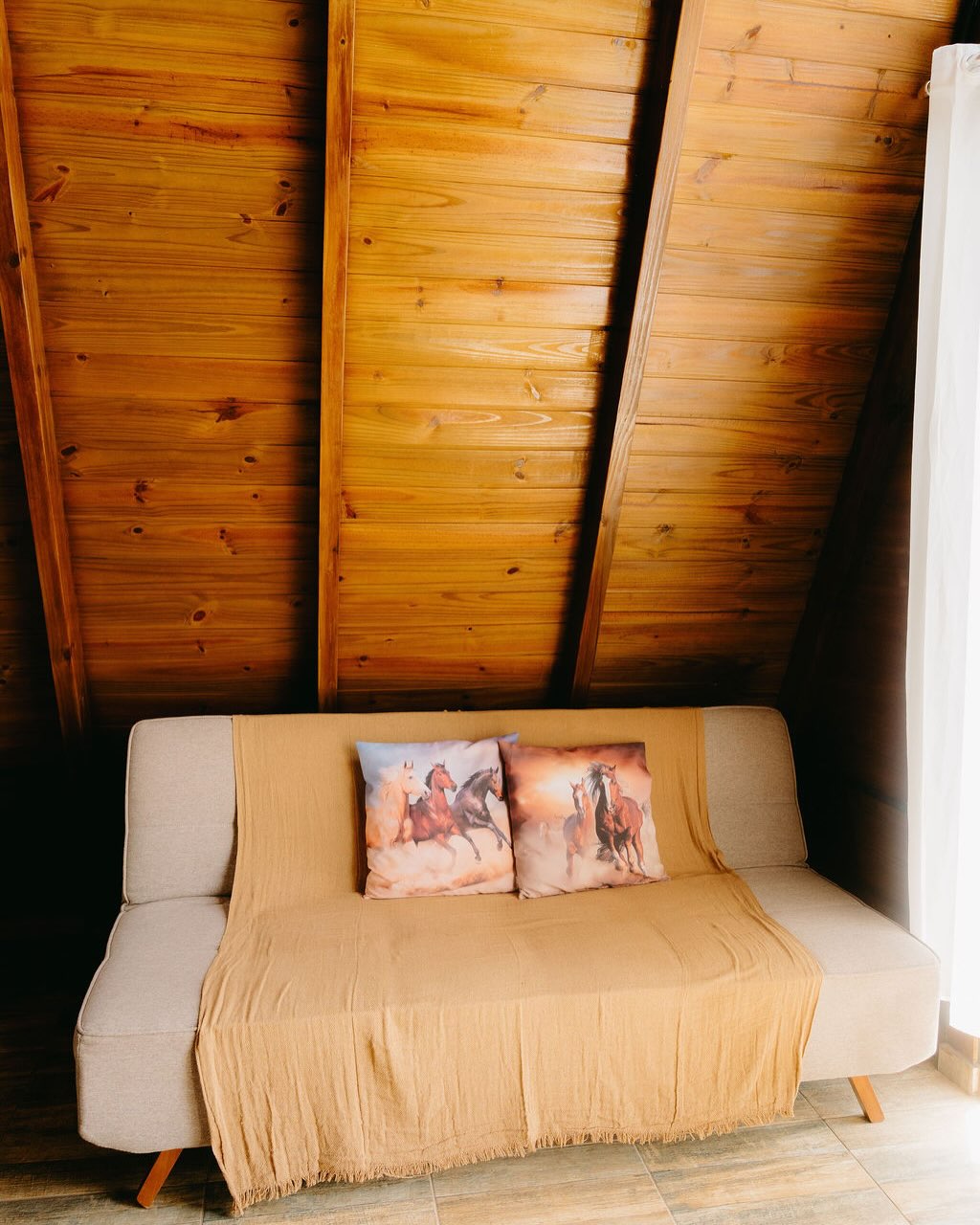 Sofá-cama na sala de madeira do Chalé Sertanejo