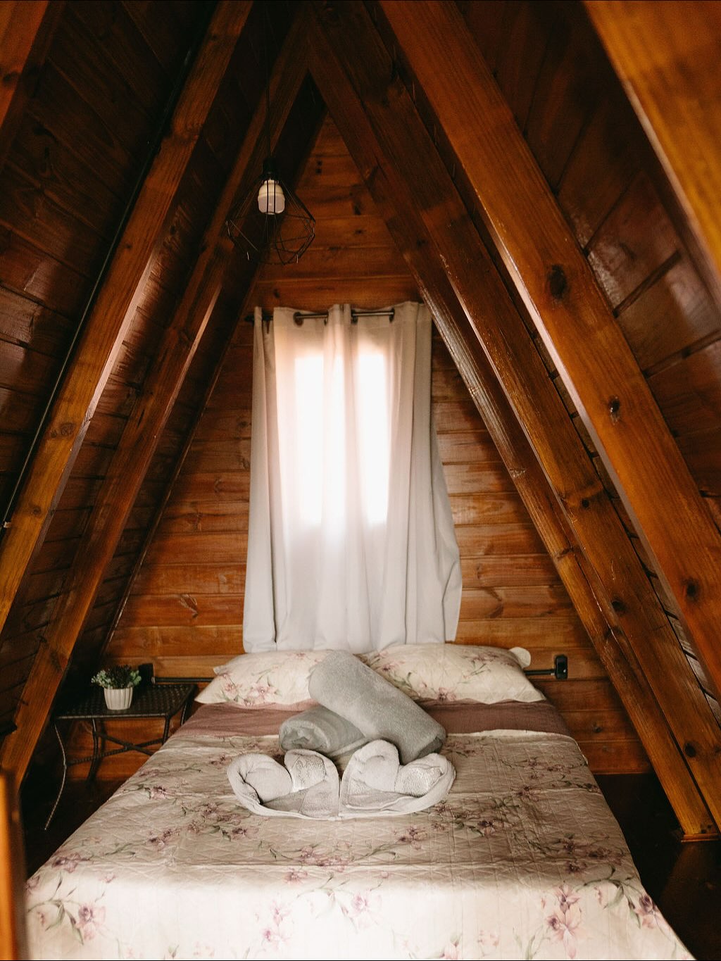 Cama de casal no mezanino de madeira do Chalé Ventania